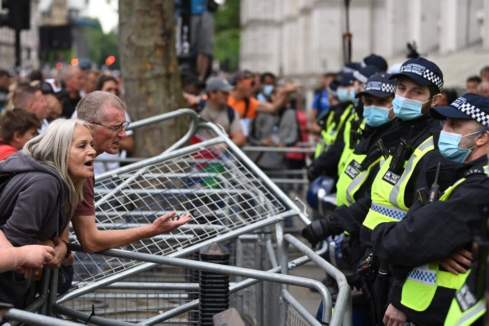 Police watch protestors during an anti-vaccine and anti-lockdown demonstration outside Downing street in central London, on June 26. — AFP