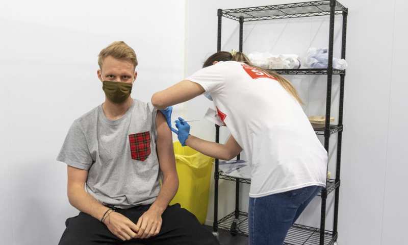 A man receives a dose of a Covid-19 vaccine, at a mass coronavirus vaccination centre in Arsenal's Emirates Stadium, in north London on Friday. &mdash; AP