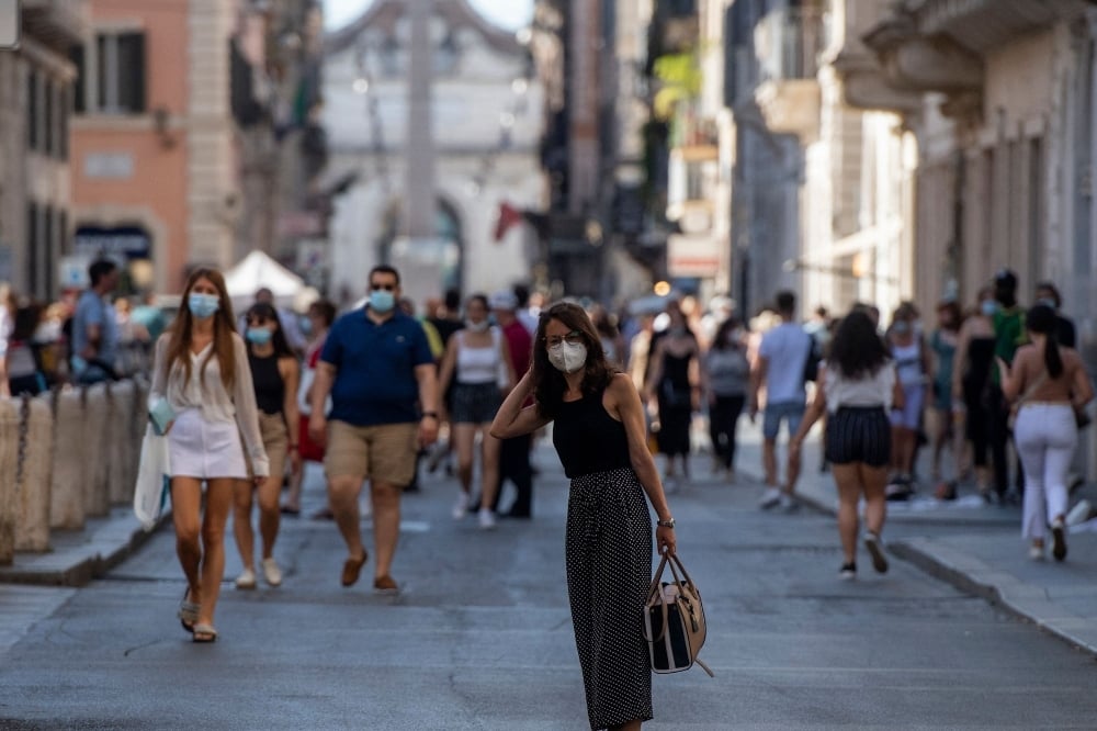 People walks along a street on the eve of Italy moving into the 'white zone' when it will not be obligatory to wear the mask outdoors in Rome on June 27. &mdash; AFP