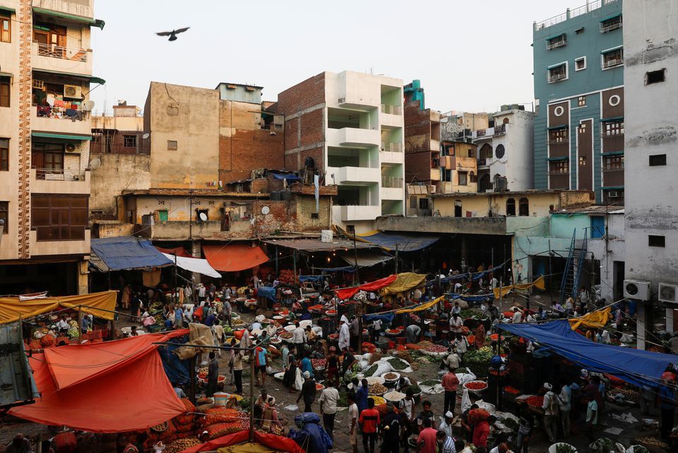 People shop at a crowded wholesale vegetable market after authorities eased coronavirus restrictions, in the old quarters of Delhi, India, June 23. — Reuters