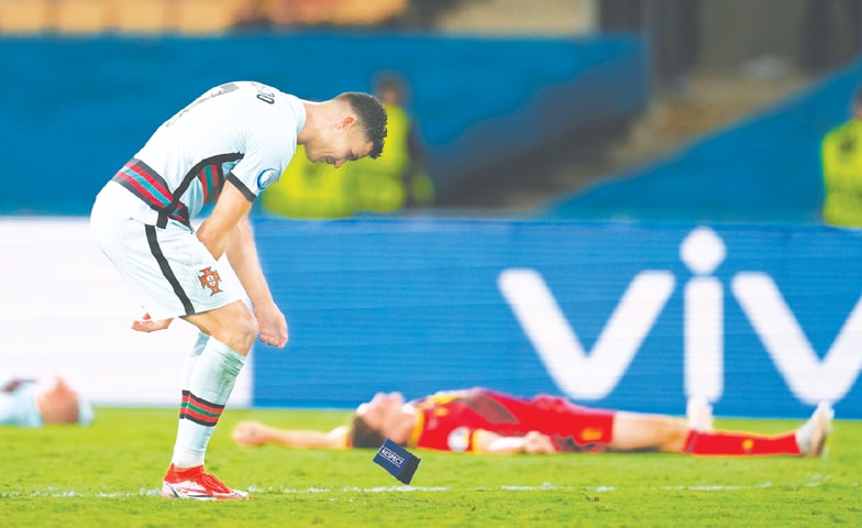 SEVILLE: Portugal’s Cristiano Ronaldo throws away the captain’s arm-band after the round-of-16 match against Belgium at La Cartuja Stadium.—Reuters