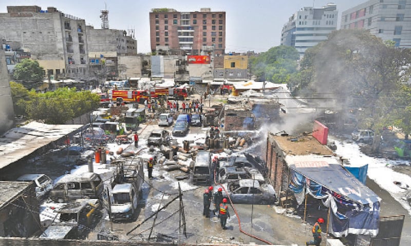 Rescue workers trying to extinguish the fire after LPG cylinder blasts in Barkat Market of Garden Town. — White Star / M Arif