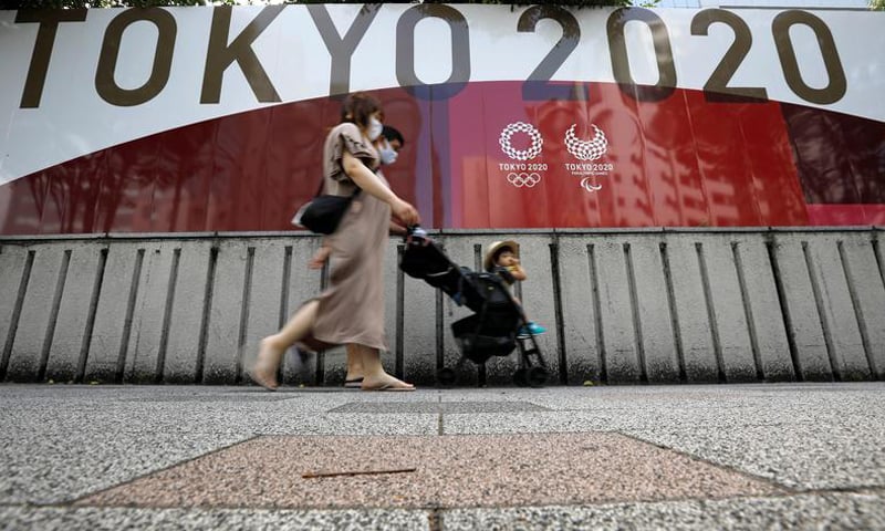 A family walks past an advertisement for Tokyo 2020 Olympic and Paralympic Games, amid the Covid-19 pandemic, in Tokyo. — Reuters/File