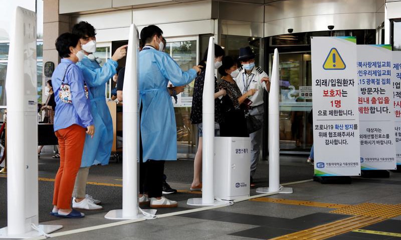 Visitors wearing masks to avoid the spread of Covid-19 fill out a form which is mandatory to get into a hospital in Seoul, South Korea. — Reuters/File