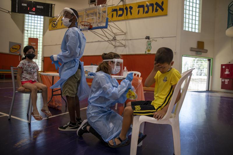 Medical personnel test Israeli children for the coronavirus at a basketball court turned into a coronavirus testing centre, in Binyamina, Israel, June 29. &mdash; AP