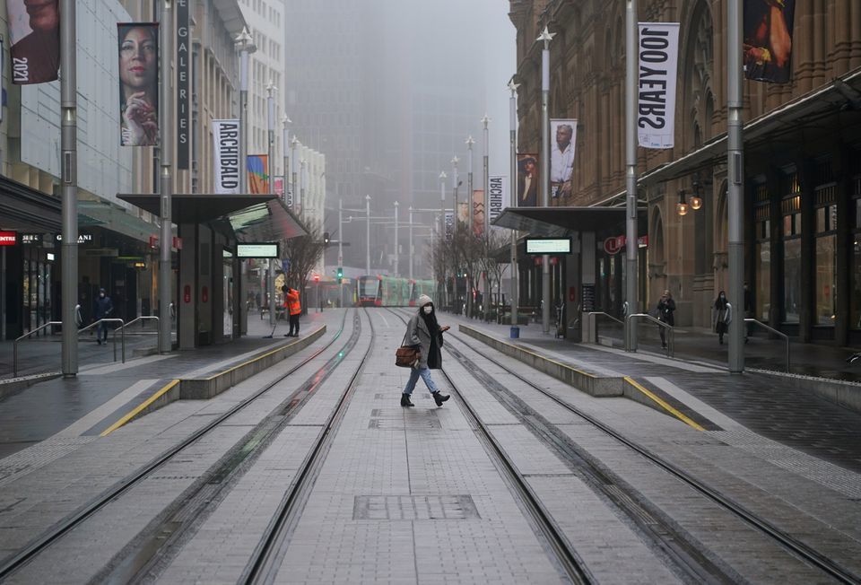 A pedestrian wearing a protective face mask walks past light rail platforms devoid of waiting passengers in the city centre at morning commute hour during a lockdown to curb the spread of a coronavirus outbreak in Sydney, Australia. &mdash; Reuters/File