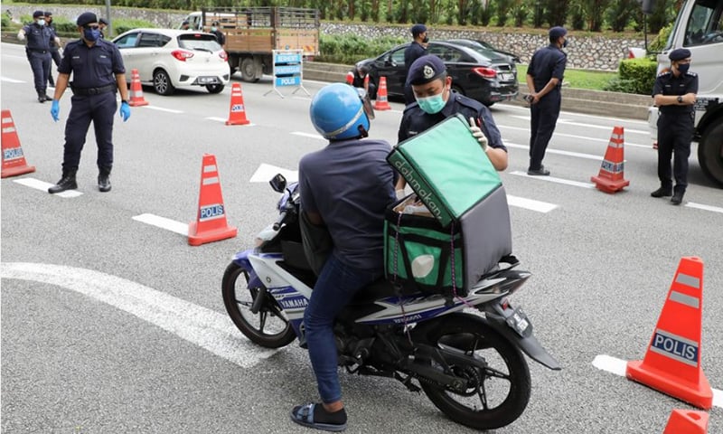 Police officers check vehicles at a road block during an enhanced lockdown, amid the coronavirus outbreak, in Kuala Lumpur, Malaysia on July 3, 2021.