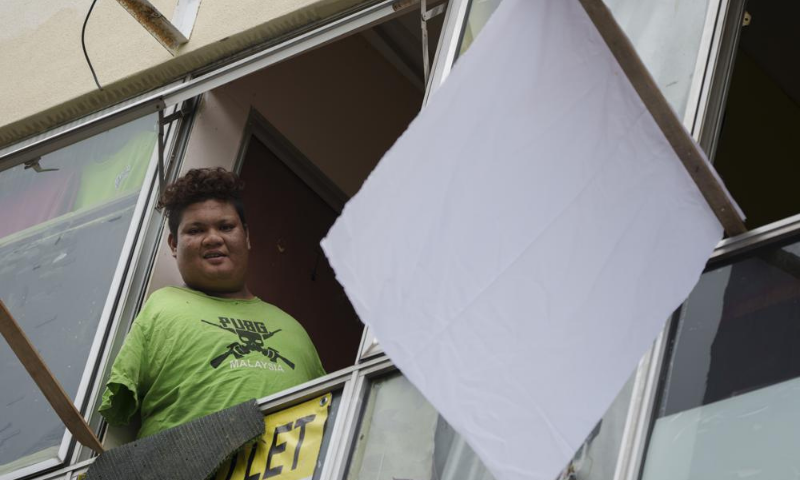 Mohamad Nor Abdullah, born without arms, looks out from the window of his rented room in Kuala Lumpur, Malaysia on Saturday. &mdash; AP