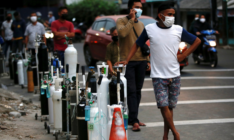 People wearing protective masks queue to refill oxygen tanks as Indonesia experiences an oxygen supply shortage amid a surge of coronavirus cases, at a filling station in Jakarta on Monday. — Reuters