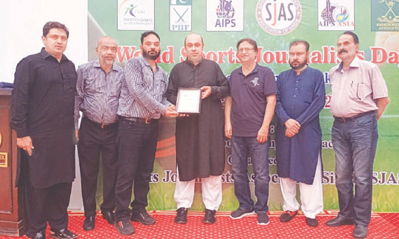 KARACHI: Secretary SJAS Asghar Azeem presents a shield to Olympian Kashif Jawad on the occasion of hockey workshop on World Sports Journalists Day.