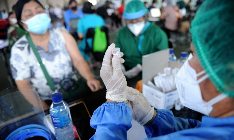 A health worker (R) prepares to administer the AstraZeneca Covid-19 coronavirus vaccine at a makeshift mass vaccination clinic in Denpasar on Indonesia's resort island of Bali on July 6. — AFP