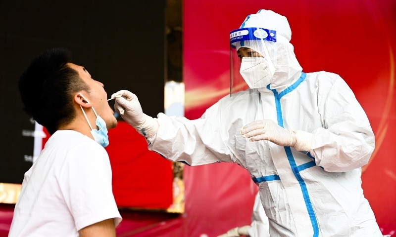 In this photo released by Xinhua News Agency, a medical worker collects a swab sample for nucleic acid test in Ruili City of southwest China's Yunnan Province, on July 5. — AP