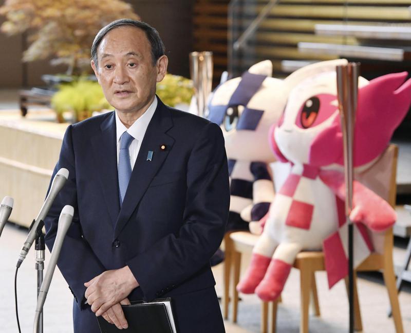 Japan's Prime Minister Yoshihide Suga speaks to media in front of the Olympics mascots at the prime minister's office in Tokyo, Japan, July 1. &mdash; AP