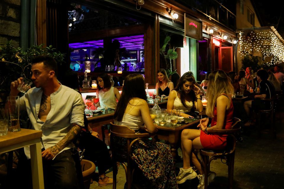 People sit at a bar in Athens, Greece, July 6. &mdash; Reuters