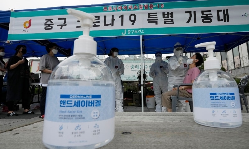 A medical worker takes a nasal sample from a woman at a coronavirus testing site in Seoul on July 8. — AP