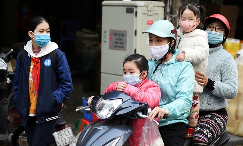 A family wears protective masks as they ride a motorbike in the street amid the coronavirus outbreak in Hanoi, Vietnam. — Reuters/File