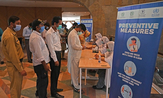 People register to get a dose of the Covid-19 vaccine at a mass vaccination center in Islamabad. — AFP/File