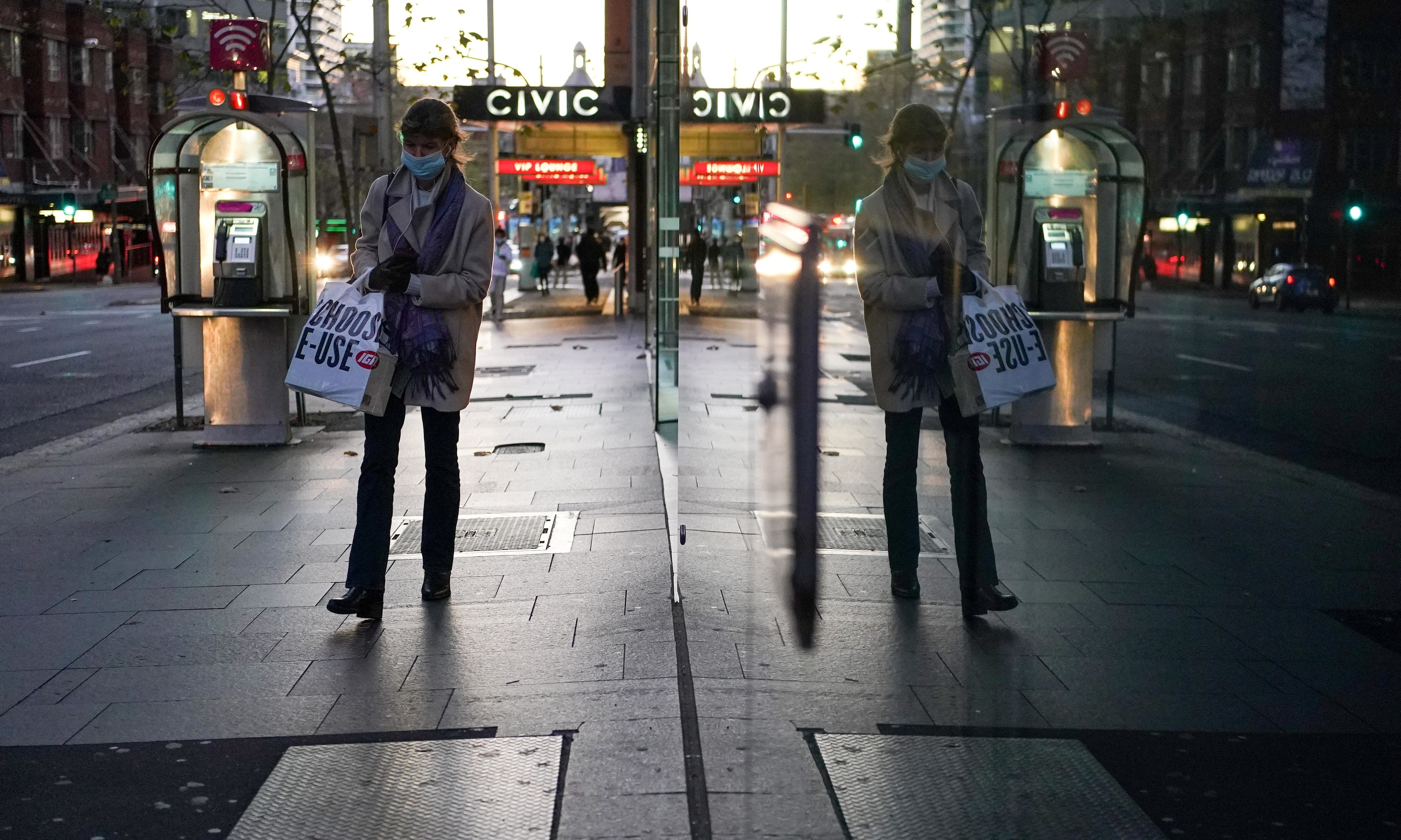 A woman wearing a protective face mask walks through the city centre during a lockdown to curb the spread of a coronavirus outbreak in Sydney, Australia. — Reuters