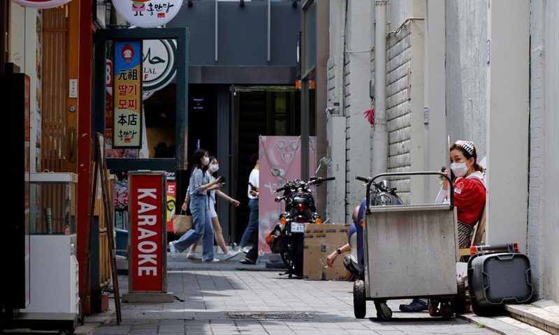 An employee takes a break outside a shop amid the Covid-19 pandemic in Seoul, South Korea. — Reuters/File