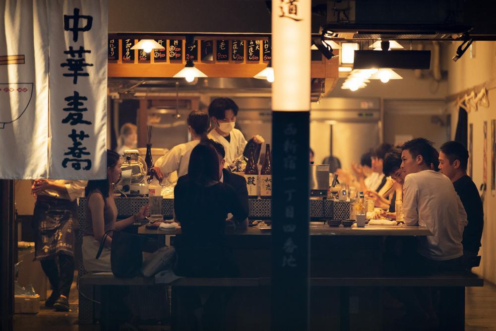 People eat and drink at a restaurant in the evening in Tokyo, Japan, July 9. &mdash; AP