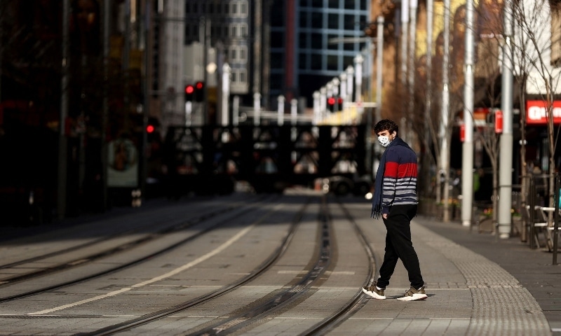 A pedestrian wearing a face mask walks down George Street in Sydney on July 13 during a lockdown as authorities stepped up efforts to curb a fast-growing coronavirus outbreak. — AFP