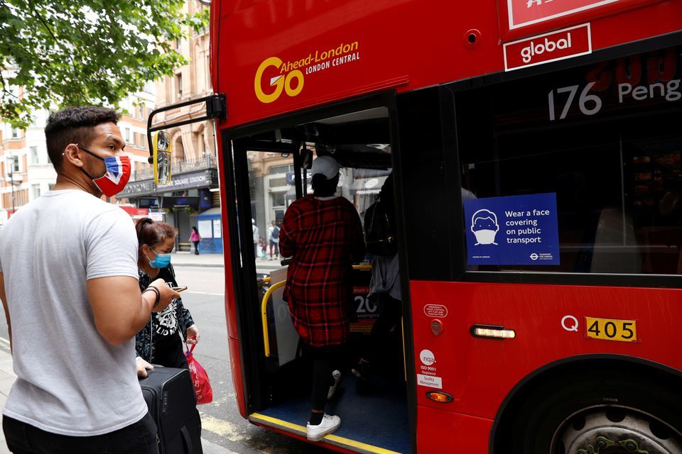 People wearing protective masks board a bus near Leicester Square in London, Britain, June 15, 2020. — Reuters/File