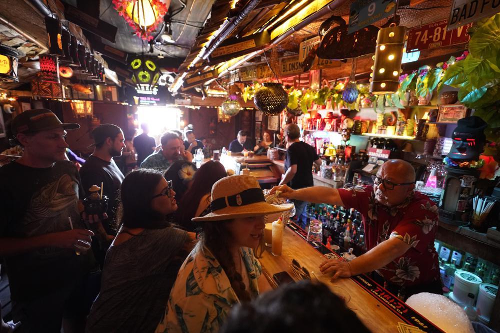 Patrons enjoy cold tropical cocktails in the tiny interior of the Tiki-Ti bar as it reopens on Sunset Boulevard in Los Angeles, US, July 7. &mdash; AP