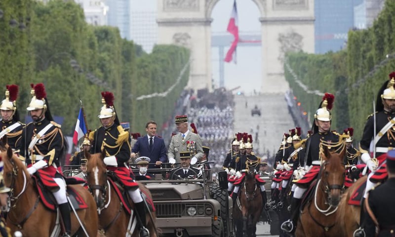 French President Emmanuel Macron (L) and French Chief of Staff Gen. Francois Lecointre (R) stand in the command car and review the troops during the Bastille Day parade on the Champs-Elysees avenue. — AP