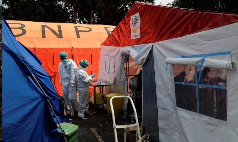 Healthcare workers in personal protective equipment work among temporary tents erected outside the emergency ward for accommodating the lack of beds at a government-run hospital amid the surge of coronavirus in Bekasi, on the outskirts of Jakarta on July 15. — Reuters