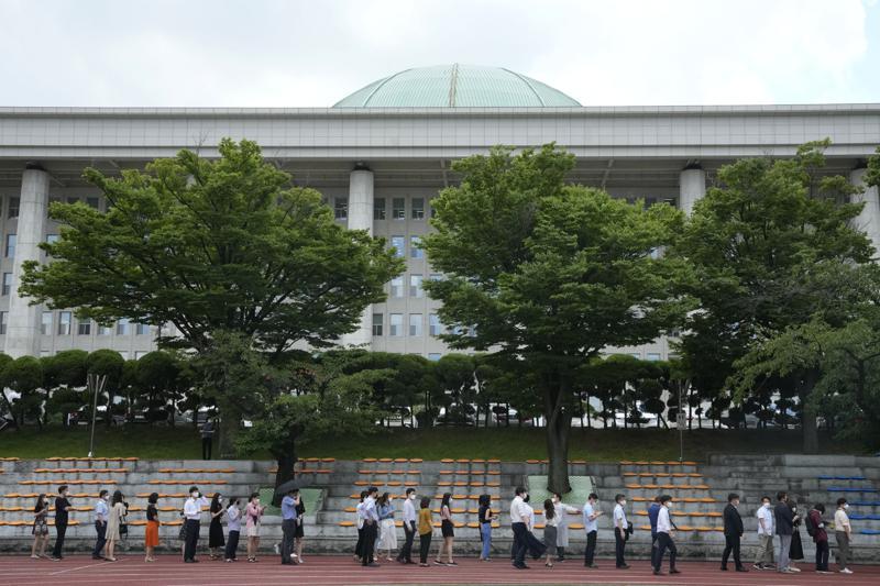 People queue in line to wait for coronavirus testing at a makeshift testing site at the National Assembly in Seoul on July 15. — AP