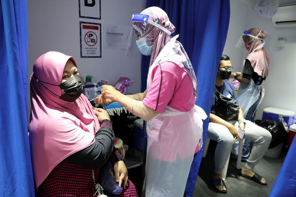 People receive doses of the Sinovac vaccine against the coronavirus in a vaccination truck in Kuala Lumpur, Malaysia, July 12. — Reuters
