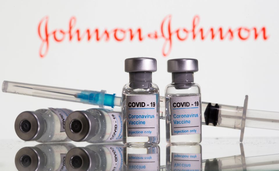 Vials labelled "Covid-19 Coronavirus Vaccine" and a syringe are seen in front of a displayed Johnson & Johnson logo. — Reuters/File