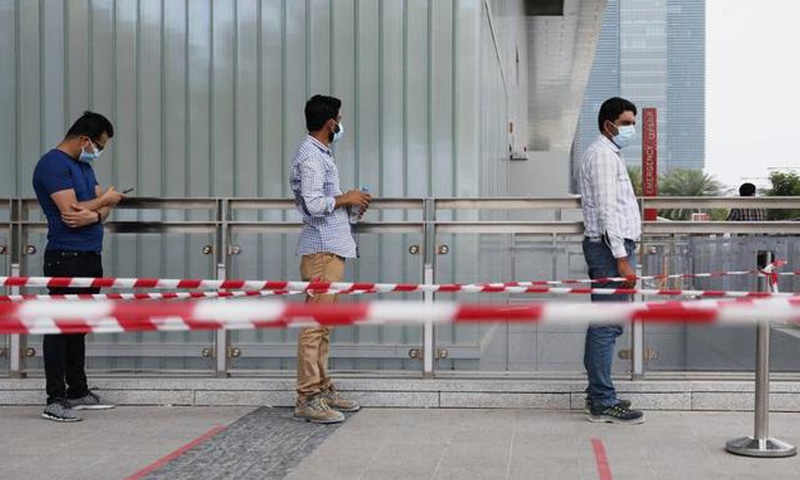 In this file photo, people wearing protective face masks wait to be tested amid the Covid-19 outbreak at Cleveland Clinic hospital in Abu Dhabi. &mdash; Reuters/File