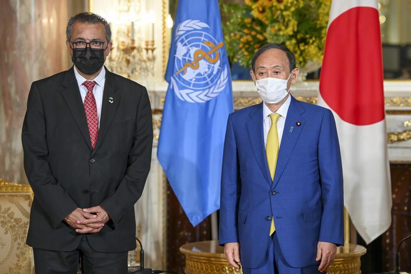 World Health Organisation Director-General Tedros Adhanom Ghebreyesus, left, and Japanese Prime Minister Yoshihide Suga wearing face masks pose for a photo at the Akasaka State Guest House in Tokyo, Japan, July 22. — AP