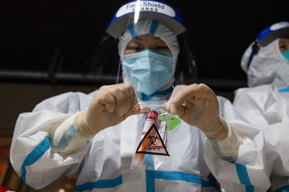 This photo shows a medical worker collecting a sample of a nucleic acid test for the coronavirus in Nanjing on July 21. — AFP
