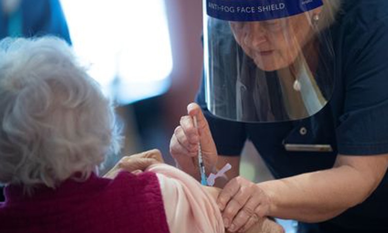 A health worker vaccinates an elderly woman with Pfizer'sCovid-19 vaccine at a temporary vaccination clinic in a church in Sollentuna, Sweden. — Reuters