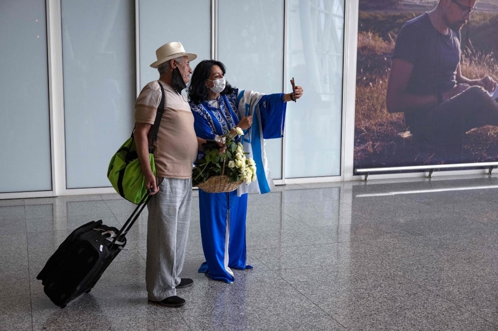 An Israeli tourist has a selfie with a hostess upon arrival at at the Marrakech-Menara International Airport on the first direct commercial flight between Israel and Morocco, on June 25. — AFP