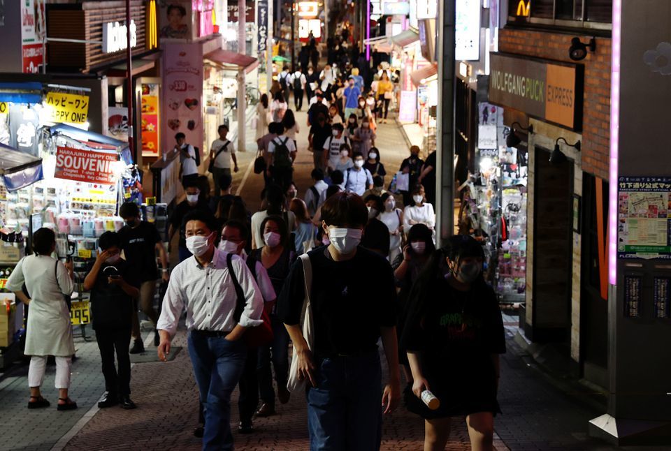 People wearing protective masks make their way at a shopping district in Tokyo, Japan, July 28. — Reuters
