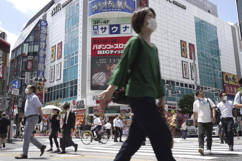 People walk across a crossing near Shimbashi Station in Tokyo, Japan, July 29. — AP