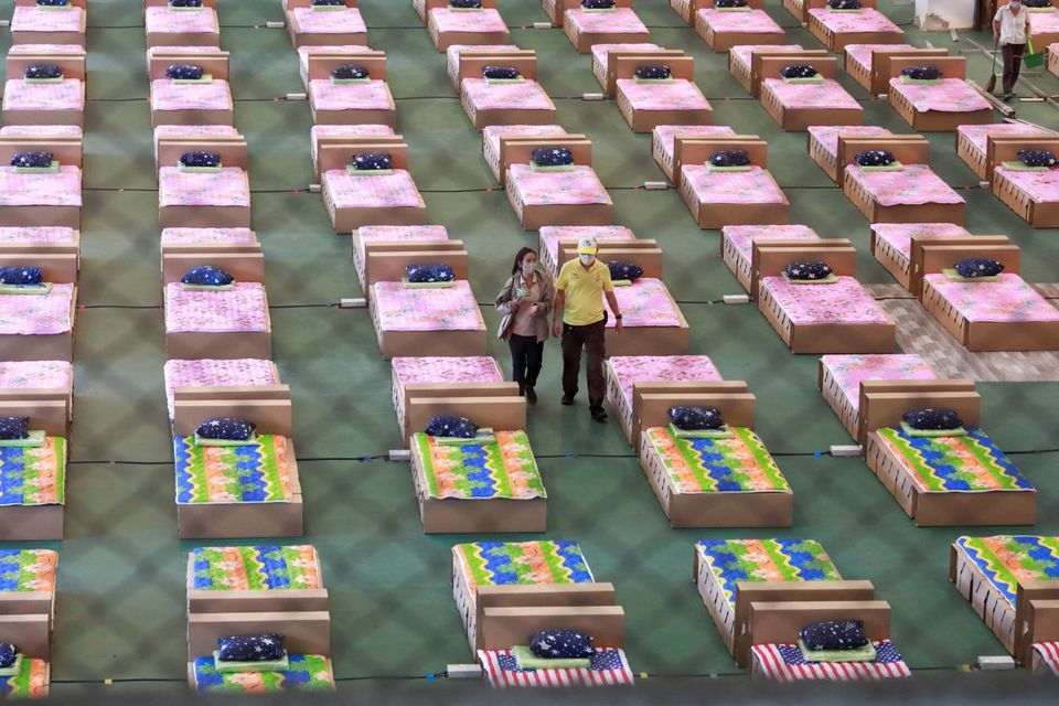 Volunteers walk as they prepare to convert an air cargo warehouse into a coronavirus field hospital at Don Mueang International Airport in Bangkok, Thailand, July 28. — Reuters
