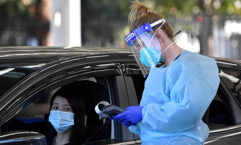 This picture taken on July 28 shows a health worker getting details from a resident at a Covid-19 drive-through testing clinic in Sydney. — AFP
