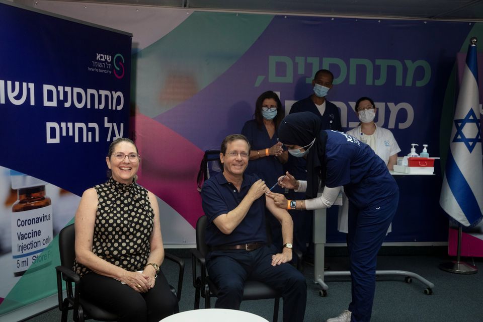 Israeli President Isaac Herzog receives a third dose of coronavirus vaccine while his wife, Michal, reacts, at Sheba Medical Centre in Ramat Gan, Israel, July 30. — Reuters