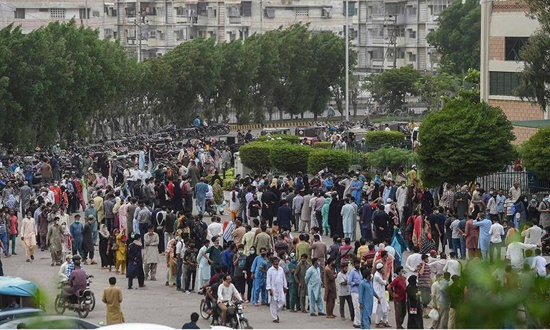 People gather in large numbers and queue up to register themselves and get inoculated with the Covid-19 vaccine at a vaccination centre in Karachi on July 29. — AFP