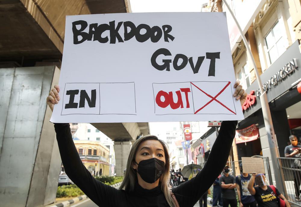 A protester holds a placard during a demonstration demanding the prime minister step down near the Independence Square in Kuala Lumpur, Malaysia on Saturday. &mdash; AP