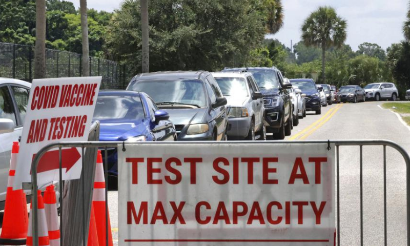 Signage stands at the ready (foreground) in case Covid-19 testing at Barnett Park reaches capacity, as cars wait in line in Orlando, Florida on July 29. &mdash; AP/File