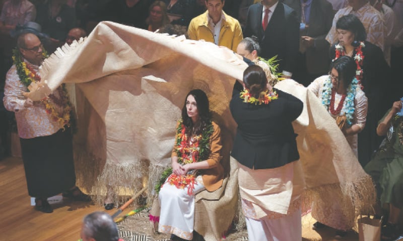 New Zealand’s Prime Minister Jacinda Ardern is ritually covered in a mat during a ceremony at which she apologised for excesses against the Pacific community.—AP