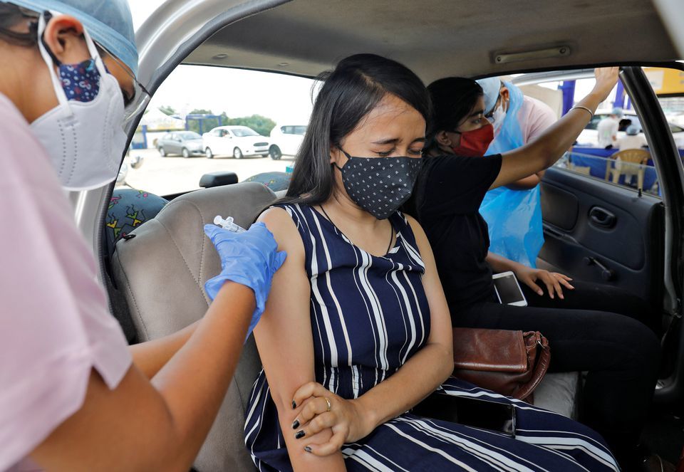 A woman receives a dose of Covishield at a drive-in vaccination kiosk in Ahmedabad, India, May 27. — Reuters