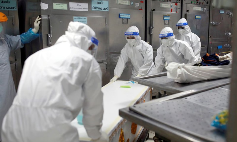 In this file photo, healthcare workers move a body to a container after a hospital morgue overwhelmed by Covid-19 deaths began to store bodies in refrigerated containers in Pathum Thani, Thailand. — Reuters/File