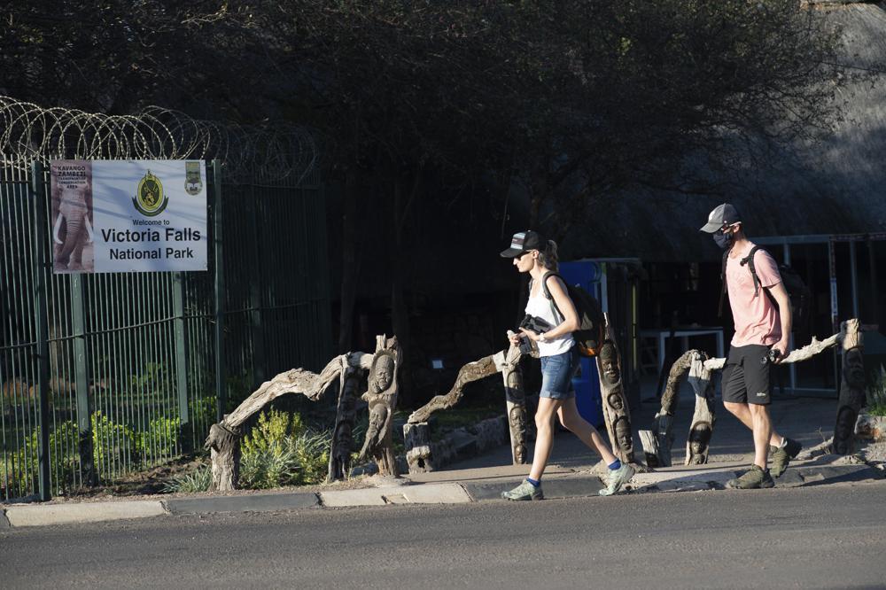 Tourists wear face masks at the entrance of Victoria Falls in Zimbabwe on Aug 6. — AP
