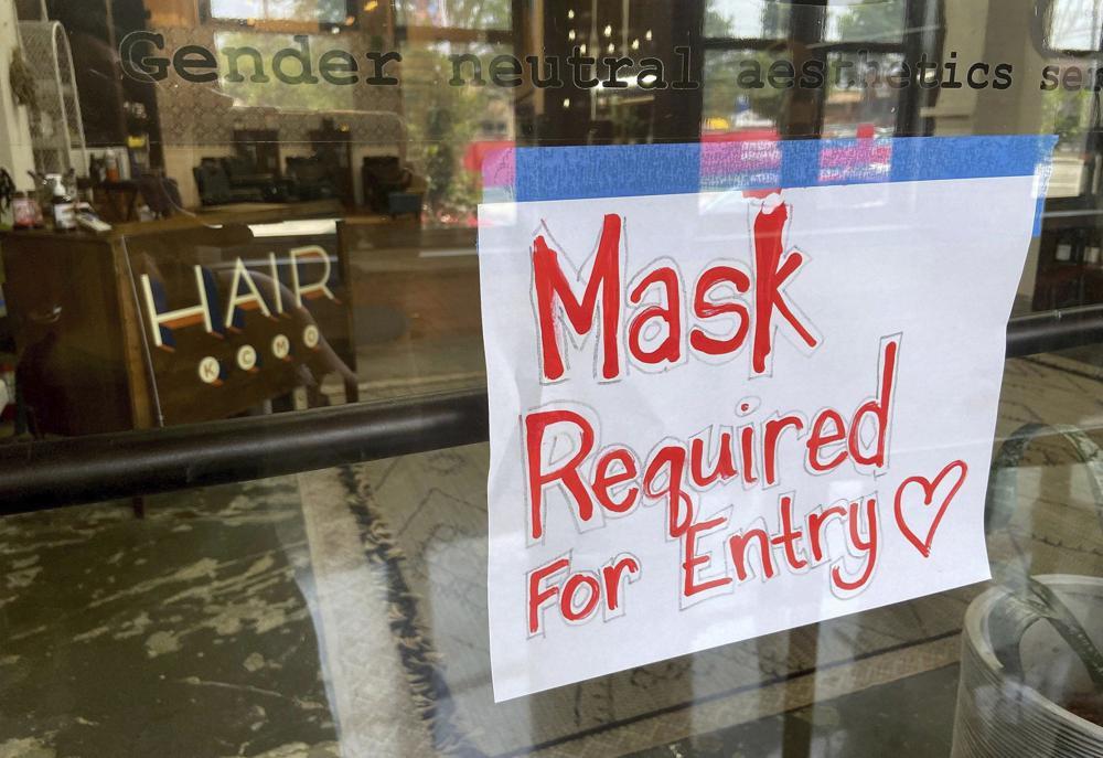 This July 28 file photo shows a sign on the door of a hair salon informing patrons that masks are required to be in the business in Kansas City, US. — AP